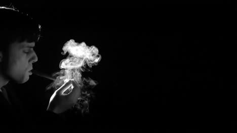 Man-lighting-cigarette-on-black-background