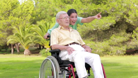 Nurse-walking-an-old-man-in-wheelchair