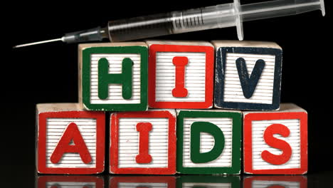 Syringe-falling-on-blocks-spelling-Aids-and-Hiv