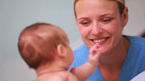 Lächelnde-Mutter-Hält-Einen-Kleinen-Jungen-Mit-Einem-Arzt