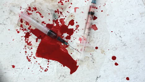 Syringes-falling-on-bloody-surface