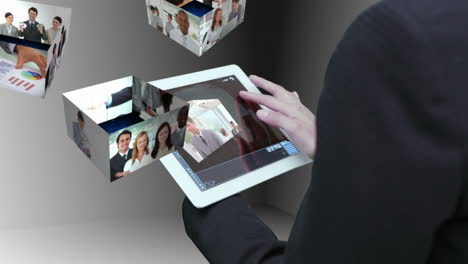 Businesswoman-using-tablet-to-view-montage-of-business-people-at-work