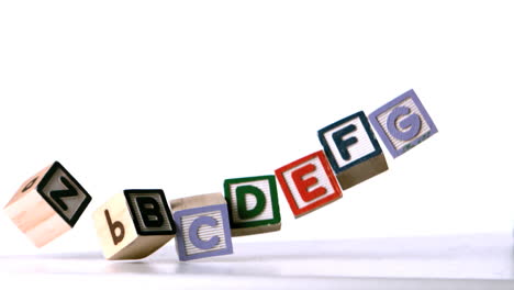 Blocks-spelling-the-alphabet-falling-over