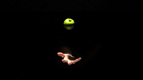 Hand-tossing-a-green-apple-