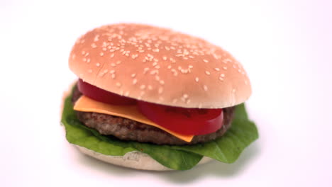 Bun-falling-onto-cheese-burger-on-white-background