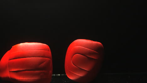 Rote-Boxhandschuhe-Fallen-Auf-Schwarzem-Hintergrund