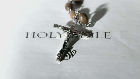 Rosary-beads-falling-onto-first-page-of-holy-bible