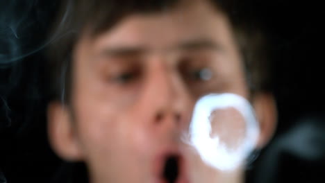 Man-blowing-smoke-rings-close-up