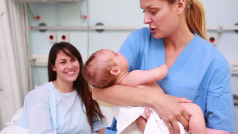 Krankenschwester-Hält-Ein-Neugeborenes-Baby