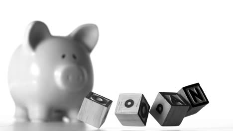 Blocks-spelling-loan-falling-over-in-front-of-a-piggy-bank