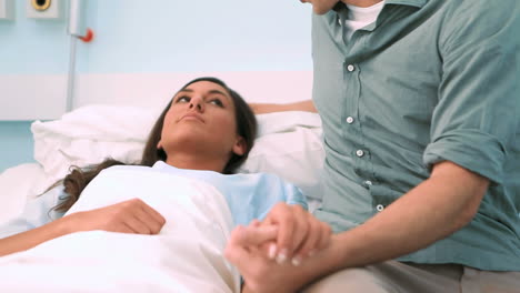 Patient-lying-on-a-medical-bed-next-to-her-boyfriend