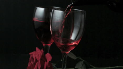 Zwei-Gläser-Rotwein-Mit-Roten-Rosen-Eingeschenkt