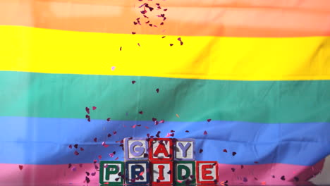 Bandera-Del-Arco-Iris-Ondeando-En-La-Brisa-Con-Bloques-Del-Orgullo-Gay-Y-Confeti-Cayendo