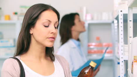 Customer-in-a-pharmacy-holding-a-bottle-of-drug