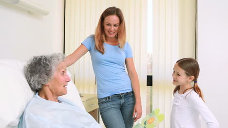 Mujer-Y-Niña-De-Pie-Junto-A-Una-Cama-De-Hospital