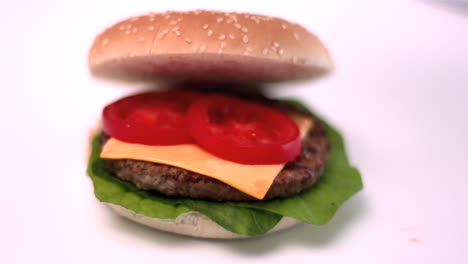 Bun-falling-onto-burger-on-white-background