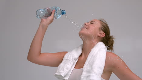 Woman-pouring-bottle-of-water-on-her-face