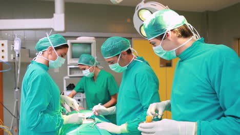 Male-nurse-preparing-tool-to-surgeon