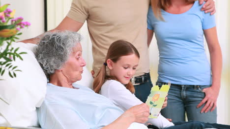 Familia-Sonriente-De-Pie-Juntos-Alrededor-De-Una-Cama-De-Hospital