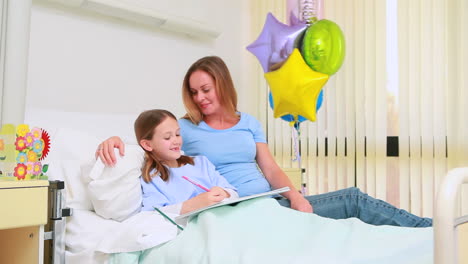 Smiling-woman-with-her-girl-in-a-bed