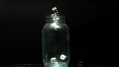 Black-and-white-dice-falling-into-glass-jar