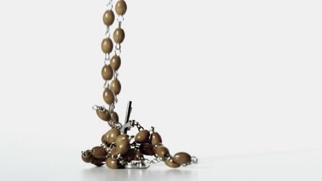 Rosary-beads-falling-onto-a-white-surface