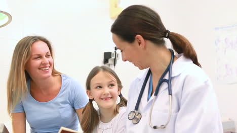 Madre-Sonriente-Con-Su-Hijo-En-La-Sala-De-Examen-De-Un-Hospital.