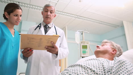 Doctor-and-a-nurse-looking-at-medical-chart-in-a-hospital