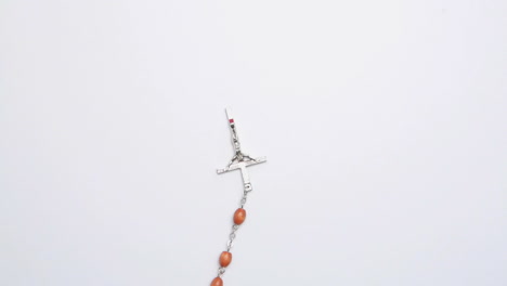 Crucifix-of-beads-on-white-surface