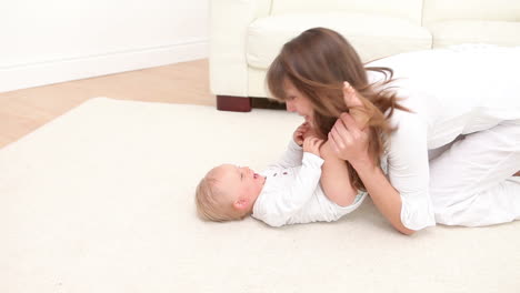 Woman-playing-with-a-baby-and-keeps-his-feet-