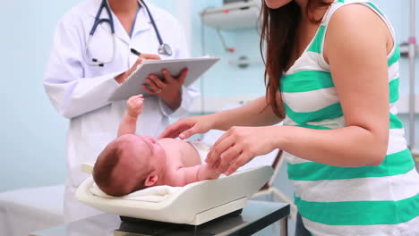 Woman-and-doctor-with-a-baby-on-a-changing-table