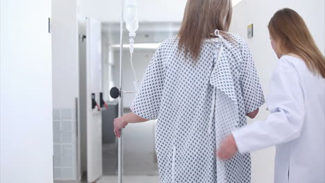 Patient-with-intravenous-drip-walking-next-to-a-doctor