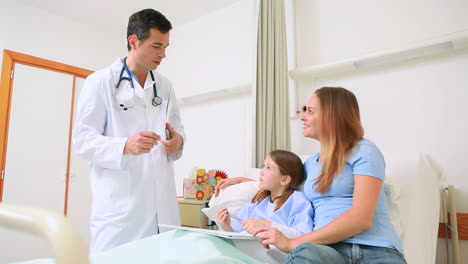 Smiling-doctor-examining-a-little-girl-in-a-hospital-ward