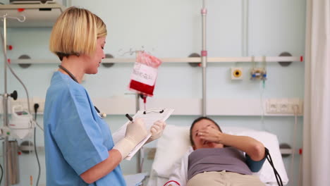 Nurse-writing-on-a-clipboard-next-to-donor