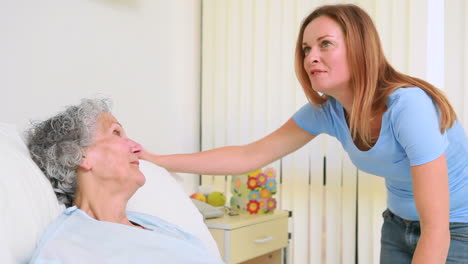 Smiling-woman-holding-the-hand-of-a-patient-in-a-room