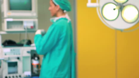 Smiling-female-surgeon-standing-next-to-a-monitor
