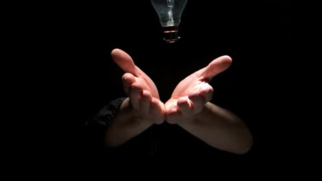 Mans-hands-tossing-transparent-bulb