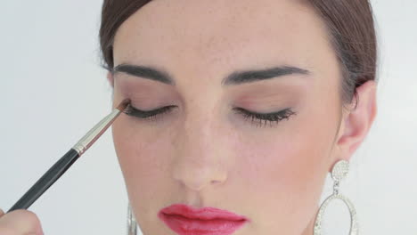 Woman-getting-applied-red-lips-and-smoky-eyes