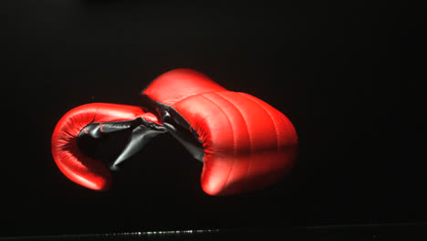 Boxing-gloves-falling-on-black-background