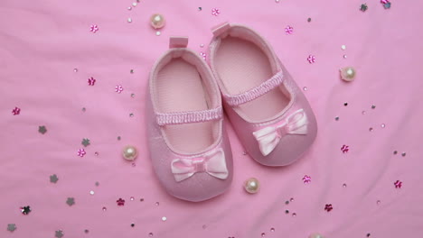 Pink-baby-booties-on-pink-blanket-with-pearls