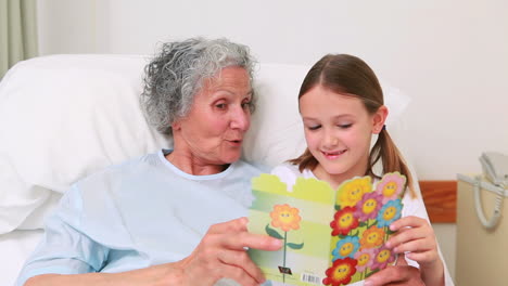 Smiling-mother-and-girl-sitting-on-the-bed-of-a-patient