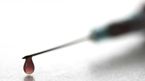 Drop-of-blood-falling-from-syringe-close-up