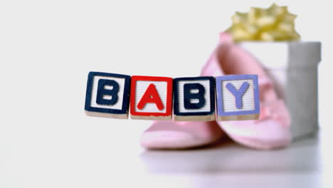 Baby-Blöcke-Fallen-Neben-Booties-Und-Geschenk-Box