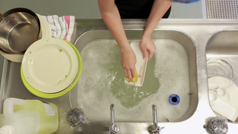 Cleaner-standing-in-a-kitchen-and-doing-the-dishes