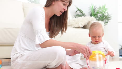 Baby-putting-a-green-dice-into-bucket-