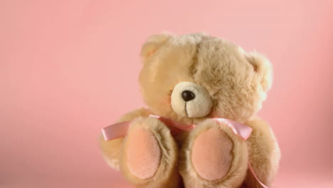 Teddy-bear-falling-and-bouncing-on-a-pink-surface