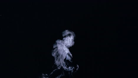 White-smoke-rising-on-black-background
