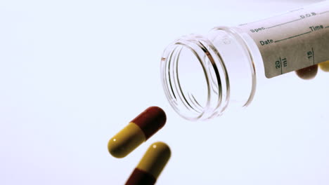 Capsule-tablets-pouring-out-of-medicine-jar