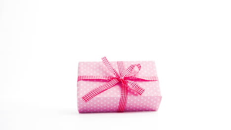 Pink-gift-wrapped-present-coming-on-screen-and-turning-with-copy-space