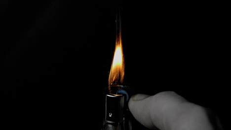 Hand-using-lighter-on-black-background-with-sparks